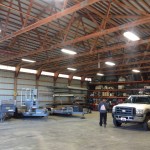 The inside of a warehouse with a truck parked in it.