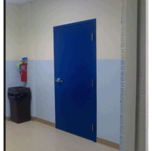 A blue door in a hallway with a trash can.