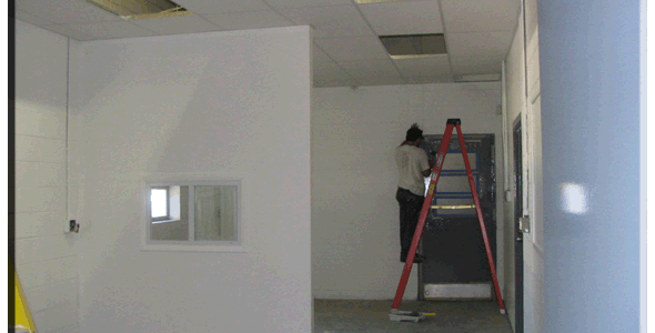 A man is standing on a ladder in a room.