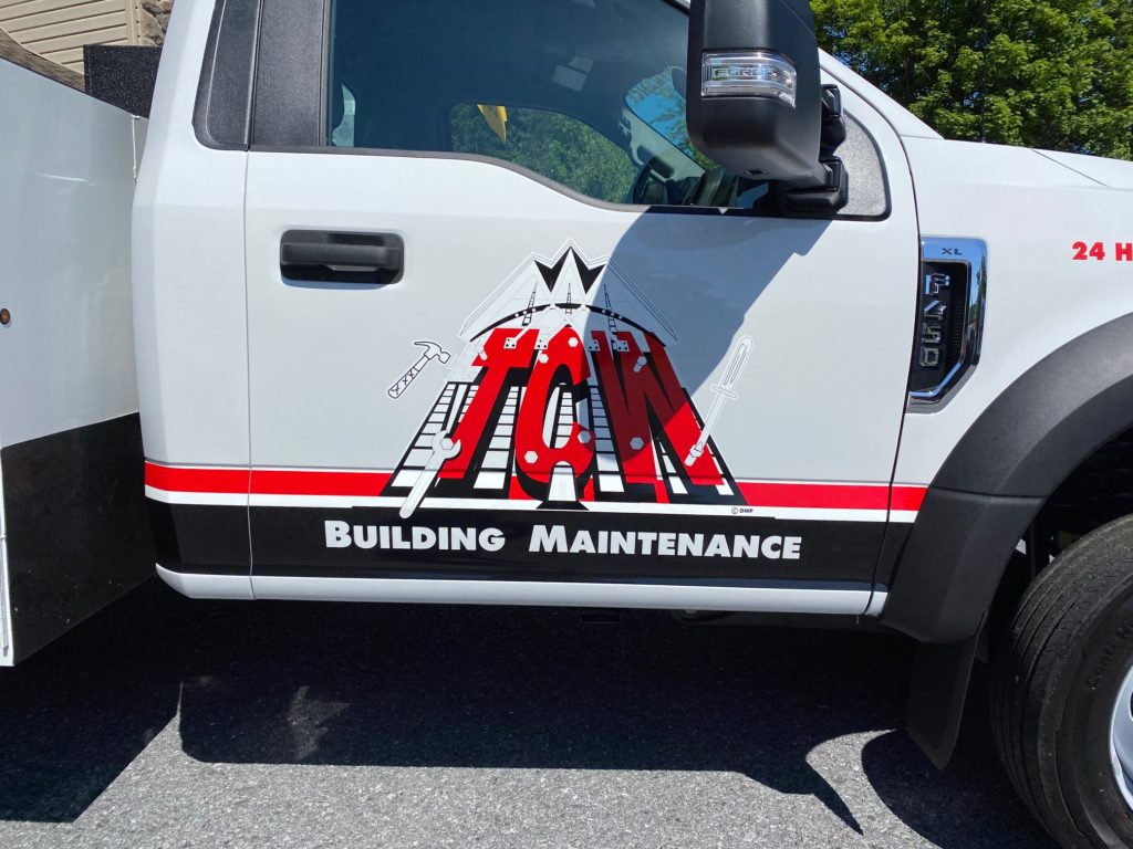 A white Ford F-350 truck with a red and black logo for commercial garage door repair services.